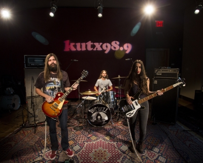 A band stands in a radio station studio